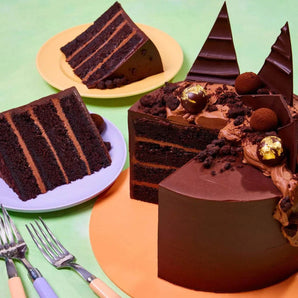 Ultimate Chocolate Cake with four layers, chocolate ganache, truffles, shards, and edible gold decorations.